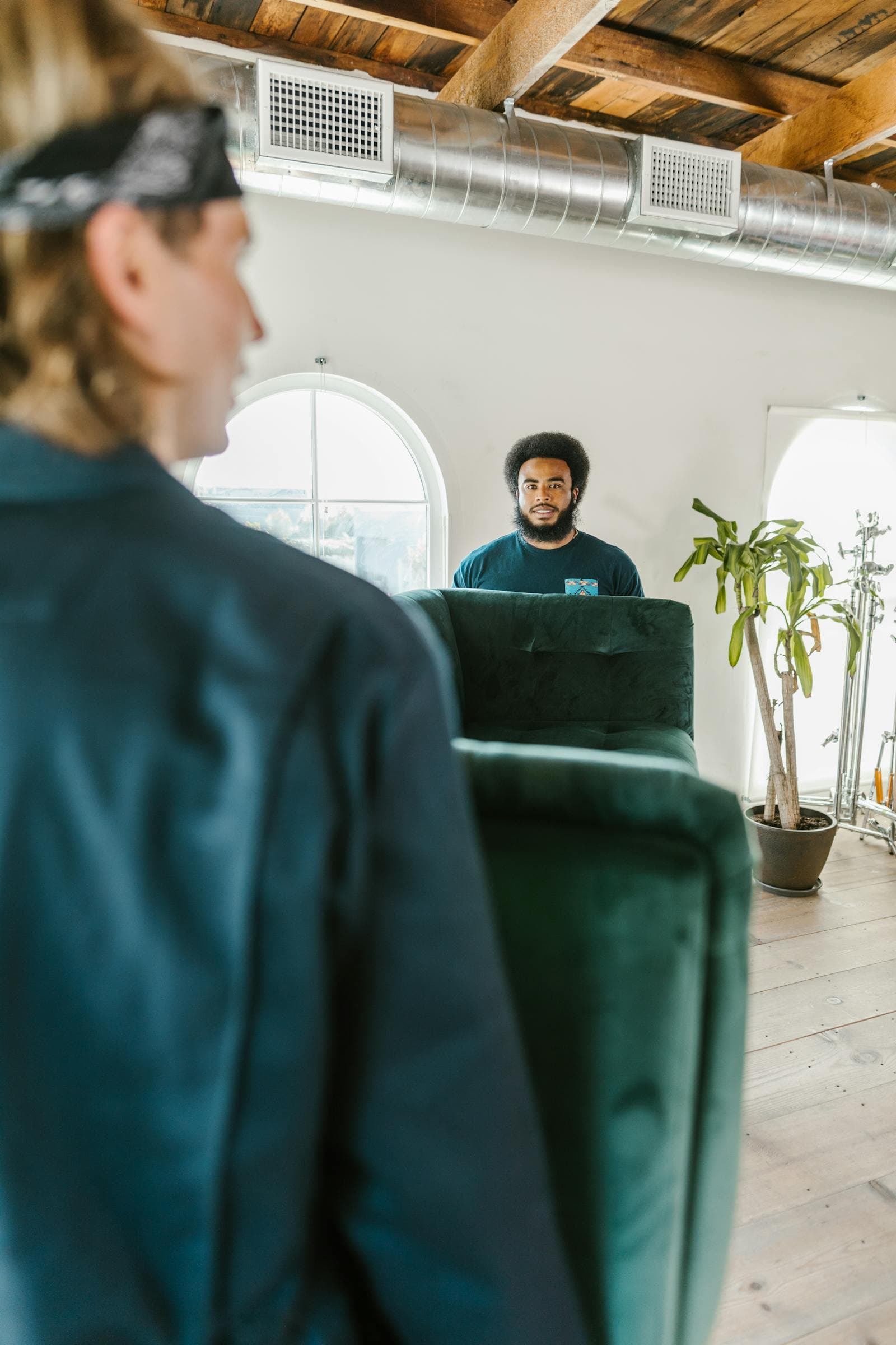 Movers carrying a sofa through a bright room