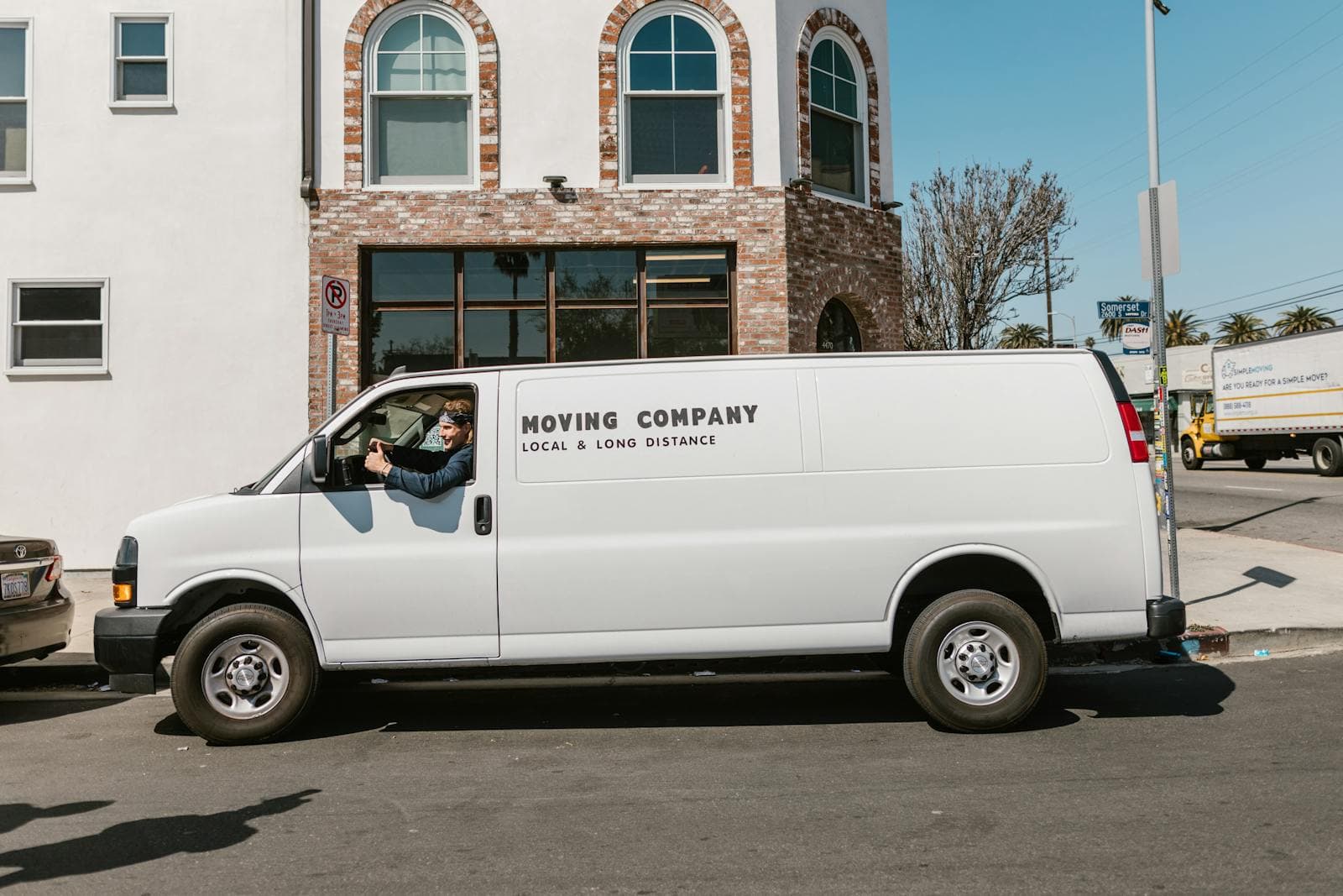 White moving company van parked on a sunny street
